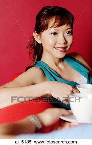 Woman holding cup, smiling, looking away View Large Photo Image Stock Photography - Woman holding cup, smiling, looking away. Fotosearch