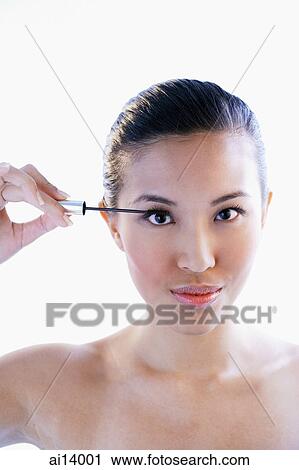 Woman holding mascara wand, looking at camera View Large Photo Image Stock Image - Woman holding mascara wand, looking at camera. Fotosearch