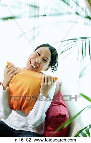 Woman holding pillow, smiling, portrait View Large Photo Image Stock Image - Woman holding pillow, smiling, portrait. Fotosearch