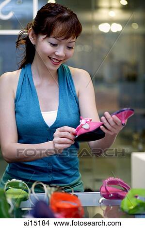 Woman holding shoe in shoe store. View Large Photo Image Picture - Woman holding shoe in shoe store.. Fotosearch