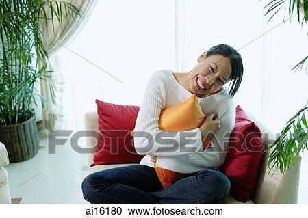 Woman hugging pillow, smiling at camera View Large Photo Image Stock Image - Woman hugging pillow, smiling at camera. Fotosearch
