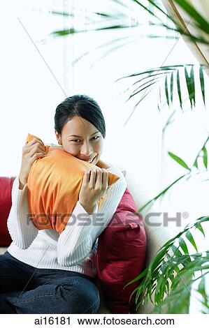 Woman hugging pillow, smiling at camera, portrait View Large Photo Image Stock Image - Woman hugging pillow, smiling at camera, portrait. Fotosearch