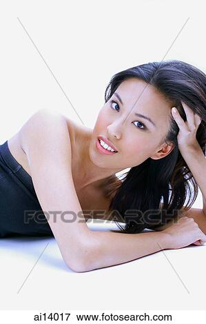 Stock Photo - Woman in black tube top, head in hands, looking at camera. Fotosearch