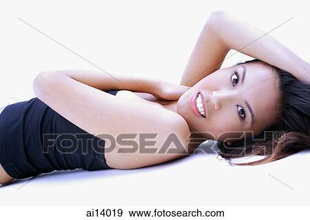 Stock Photo - Woman in black tube top, lying on back, looking at camera. Fotosearch