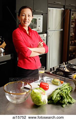 Woman in kitchen, arms crossed, looking at camera View Large Photo Image Stock Image - Woman in kitchen, arms crossed, looking at camera. Fotosearch