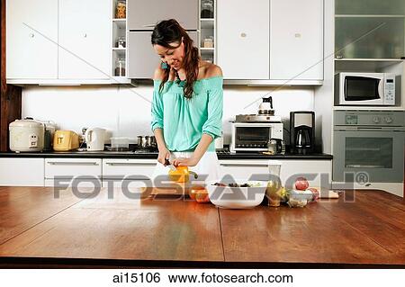 Woman in kitchen, cutting vegetables View Large Photo Image Stock Photograph - Woman in kitchen, cutting vegetables. Fotosearch