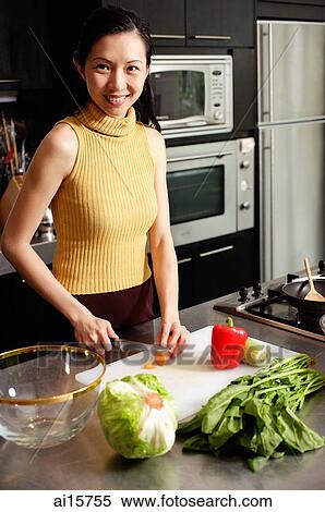 Woman in kitchen, cutting vegetables, smiling at camera View Large Photo Image Stock Photography - Woman in kitchen, cutting vegetables, smiling at camera. Fotosearch