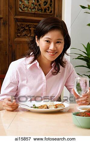 Woman in pink blouse having a meal, looking at camera View Large Photo Image Stock Photo - Woman in pink blouse having a meal, looking at camera. Fotosearch