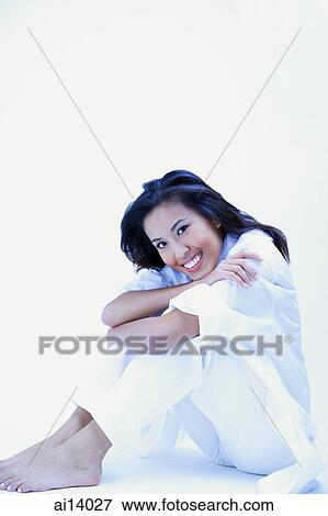 Woman in white shirt and pants, hugging knees, smiling at camera View Large Photo Image Stock Photo - Woman in white shirt and pants, hugging knees, smiling at camera. Fotosearch