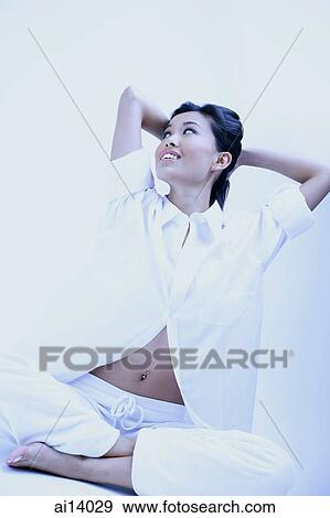 Woman in white shirt and pants, legs crossed, hands behind head View Large Photo Image Stock Photo - Woman in white shirt and pants, legs crossed, hands behind head. Fotosearch