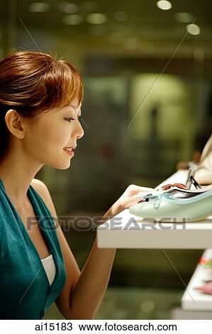 Woman looking at shoes in shoe store, side view View Large Photo Image Stock Image - Woman looking at shoes in shoe store, side view. Fotosearch