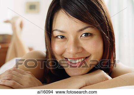 Woman lying on front, arms crossed, looking at camera View Large Photo Image Picture - Woman lying on front, arms crossed, looking at camera. Fotosearch