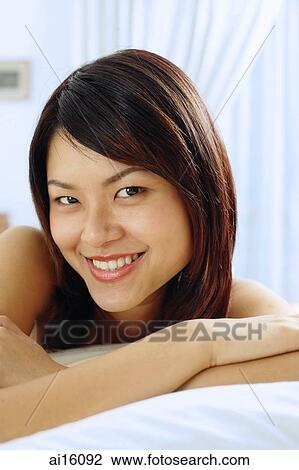 Woman lying on front, smiling at camera View Large Photo Image Stock Image - Woman lying on front, smiling at camera. Fotosearch