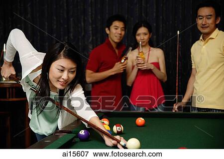 Stock Photo - Woman playing snooker, people watching. Fotosearch