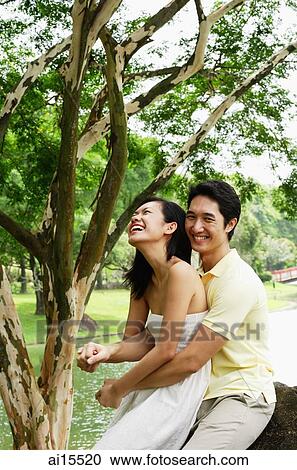 Woman sitting on mans lap, man embracing her, both smiling View Large Photo Image Stock Image - Woman sitting on mans lap, man embracing her, both smiling. Fotosearch