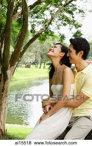 Woman sitting on mans lap, man embracing her View Large Photo Image Stock Photo - Woman sitting on mans lap, man embracing her. Fotosearch