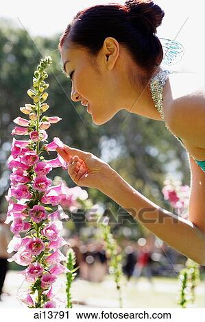 Woman smelling flowers, side view View Large Photo Image Stock Image - Woman smelling flowers, side view. Fotosearch