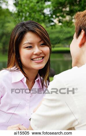 Woman smiling at man sitting opposite from her View Large Photo Image Stock Photography - Woman smiling at man sitting opposite from her. Fotosearch