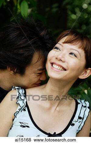 Woman smiling, looking away, man nuzzling her neck View Large Photo Image Stock Photo - Woman smiling, looking away, man nuzzling her neck. Fotosearch