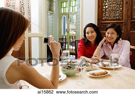 Woman taking pictures of friends, holding camera View Large Photo Image Stock Image - Woman taking pictures of friends, holding camera. Fotosearch