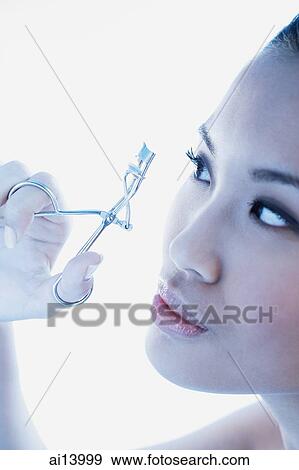 Woman using eyelash curler View Large Photo Image Stock Photo - Woman using eyelash curler. Fotosearch
