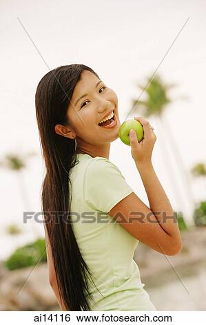 Stock Photograph - Woman with apple, looking at camera. Fotosearch
