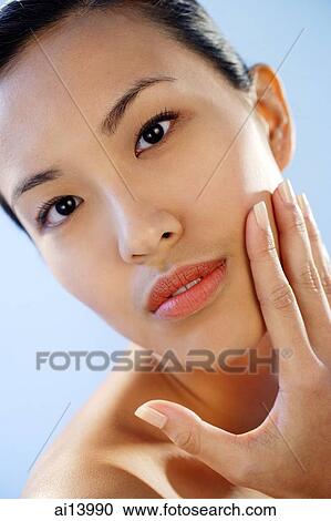 Woman with hand on face, looking at camera View Large Photo Image Stock Image - Woman with hand on face, looking at camera. Fotosearch