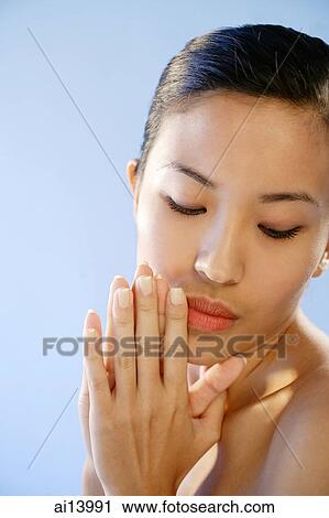 Woman with hands together, eyes downcast View Large Photo Image Stock Image - Woman with hands together, eyes downcast. Fotosearch