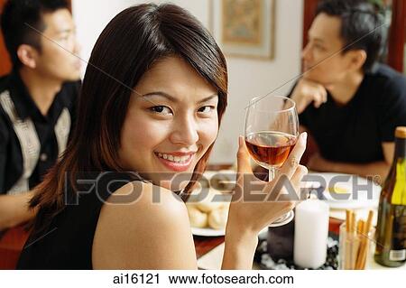 Woman with wine glass, looking over shoulder, smiling View Large Photo Image Stock Image - Woman with wine glass, looking over shoulder, smiling. Fotosearch
