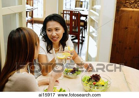 Women at a cafe, eating a salad lunch View Large Photo Image Stock Photo - Women at a cafe, eating a salad lunch. Fotosearch