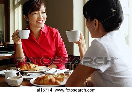 Women having tea at cafe, sitting face to face View Large Photo Image Picture - Women having tea at cafe, sitting face to face. Fotosearch