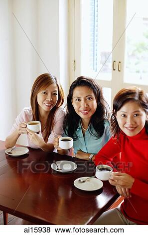 Women in cafe with cups and saucers, smiling at camera View Large Photo Image Stock Photo - Women in cafe with cups and saucers, smiling at camera. Fotosearch