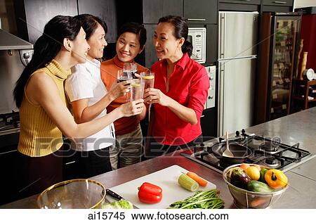Women in kitchen, holding wine glasses, toasting View Large Photo Image Stock Photography - Women in kitchen, holding wine glasses, toasting. Fotosearch