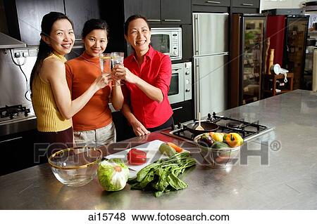Women in kitchen, toasting, smiling at camera View Large Photo Image Stock Photo - Women in kitchen, toasting, smiling at camera. Fotosearch
