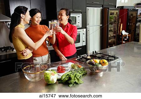 Women in kitchen, toasting View Large Photo Image Stock Photo - Women in kitchen, toasting. Fotosearch