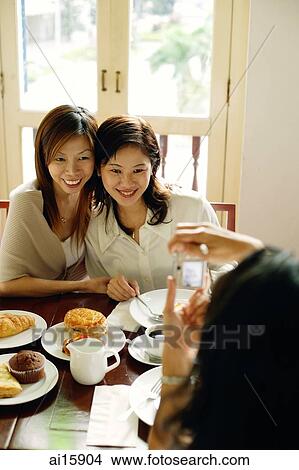 Picture - Women posing for photograph, smiling. Fotosearch