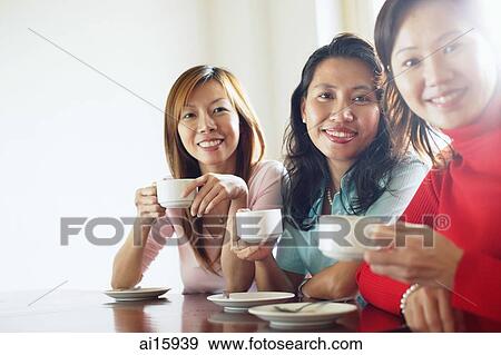 Women sitting at table with cups and saucers, looking at camera View Large Photo Image Stock Photo - Women sitting at table with cups and saucers, looking at camera. Fotosearch