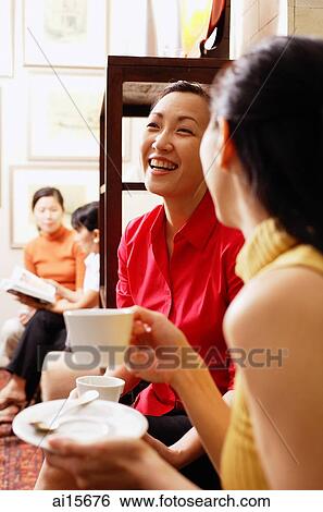 Women sitting, smiling, holding cups and saucers View Large Photo Image Stock Photograph - Women sitting, smiling, holding cups and saucers. Fotosearch