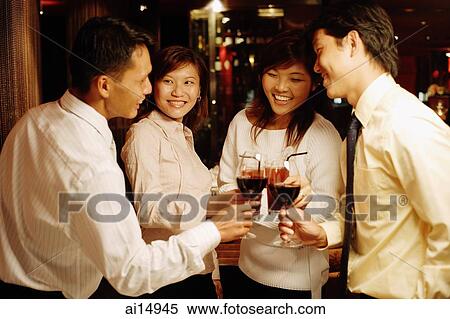Stock Photography - Young executives standing, toasting with wine. Fotosearch