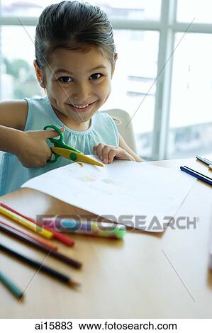 Young girl holding scissors, cutting paper, smiling at camera View Large Photo Image Stock Image - Young girl holding scissors, cutting paper, smiling at camera. Fotosearch