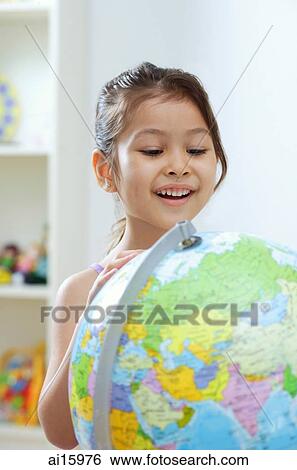 Stock Photograph - Young girl looking at globe, big smile. Fotosearch