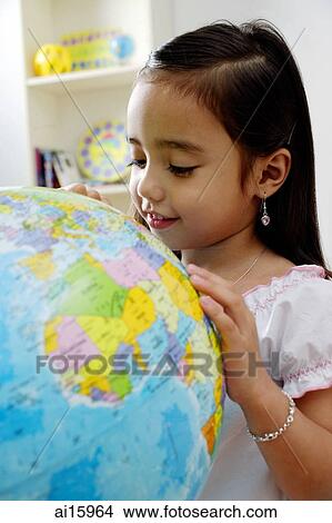 Young girl looking at globe, smiling View Large Photo Image Picture - Young girl looking at globe, smiling. Fotosearch