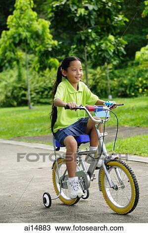 Stock Image - Young girl on bicycle. Fotosearch