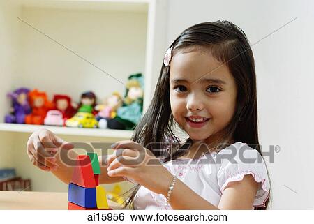 Stock Photograph - Young girl playing with building blocks. Fotosearch