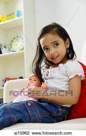 Young girl playing with doll, smiling View Large Photo Image Stock Image - Young girl playing with doll, smiling. Fotosearch