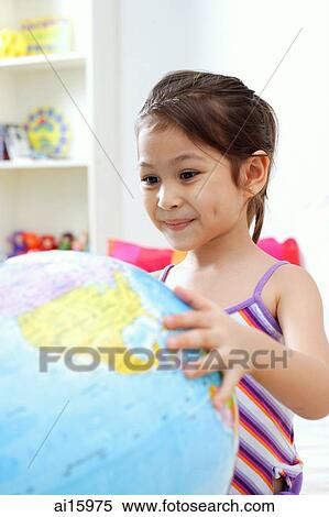 Young girl smiling and looking at globe View Large Photo Image Stock Photography - Young girl smiling and looking at globe. Fotosearch