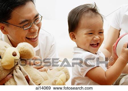 Young girl smiling, father next to her holding stuffed toy View Large Photo Image Stock Photo - Young girl smiling, father next to her holding stuffed toy. Fotosearch