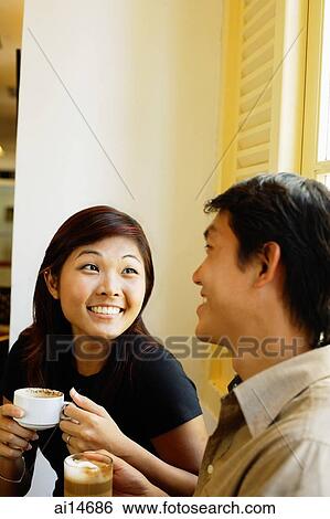 Young man and woman, holding coffee cups, looking at each other View Large Photo Image Stock Photograph - Young man and woman, holding coffee cups, looking at each other. Fotosearch