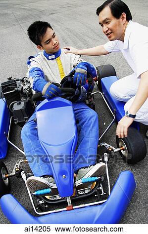 Young man in go-cart, father crouching down next to him View Large Photo Image Stock Photography - Young man in go-cart, father crouching down next to him. Fotosearch