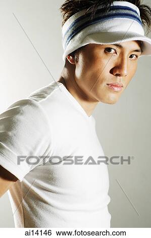 Stock Photograph - Young man looking at camera, portrait. Fotosearch